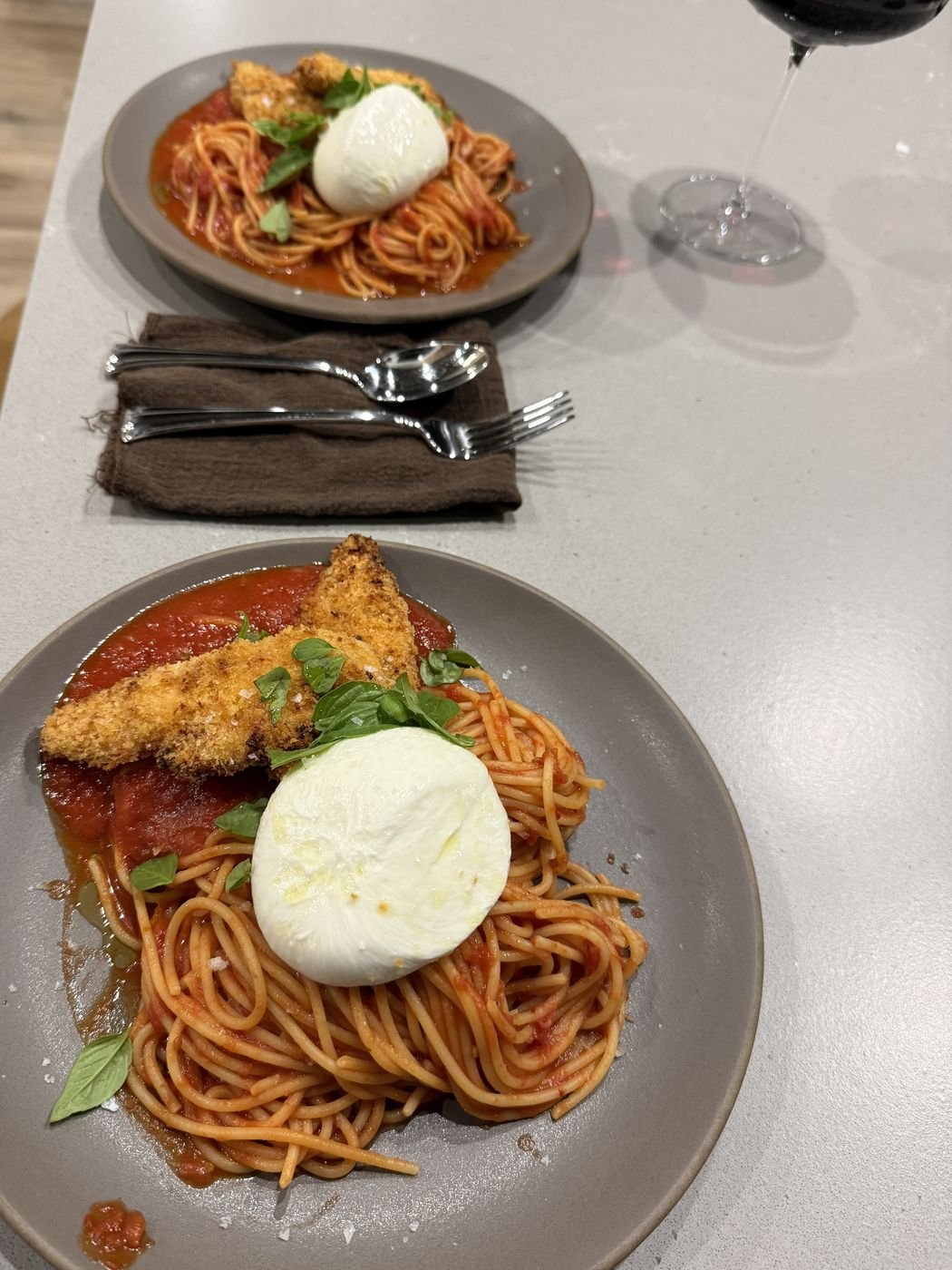 Spaghetti in tomato sauce with a crispy chicken cutlet and burrata