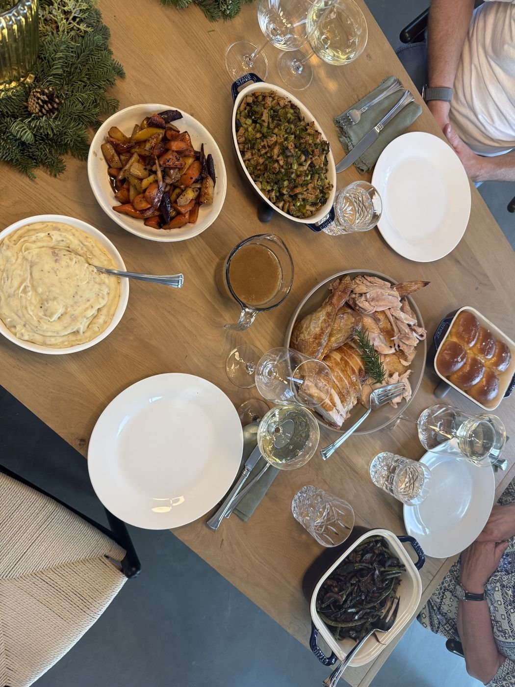 A Thanksgiving table crowded with dishes, seen from above